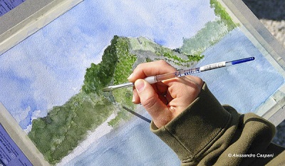Un artista sta disegnando il lago di Lecco con gli acquarelli